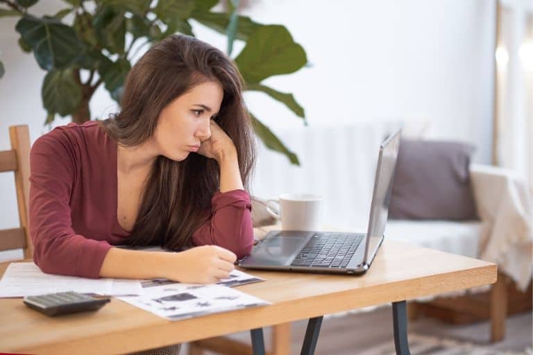 woman looking bored at her laptop